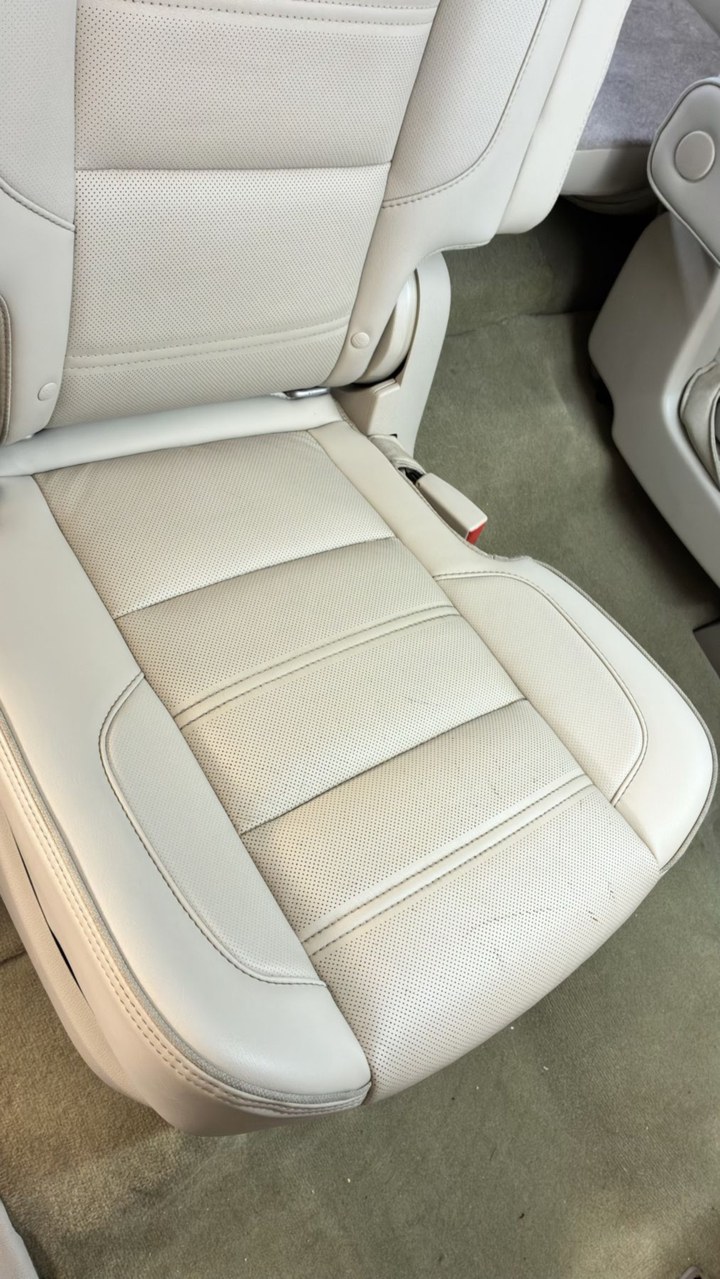The same leather seat clean and conditioned after an interior detail